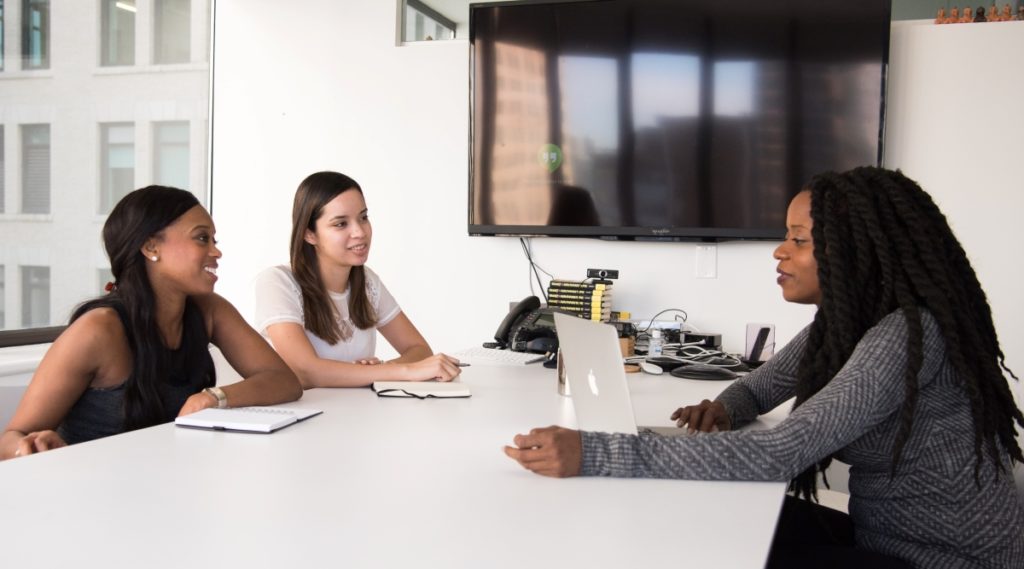 Two women interviewing another woman at a table