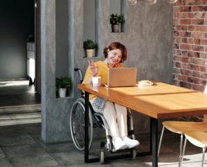 Woman working remotely on laptop while in wheelchair
